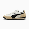 Sneaker PUMA bianca con striscia sagomata nera, dettagli in pelle scamosciata beige e suola nera.