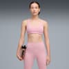 Su sfondo grigio, una modella tiene una borraccia Puma, indossando reggiseno sportivo e leggings rosa.