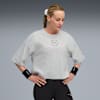 Vor grauem Hintergrund blickt ein Model in Sportkleidung mit Händen auf den Hüften nach unten.