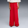 Sur fond gris, un modèle porte un pantalon rouge à bande blanche et un t-shirt blanc.