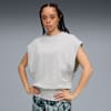 Op grijs poseert een model met handen op de heupen, in een grijze top en een broek met print.