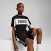 Su uno sfondo grigio, un modello posa indossando una t-shirt PUMA nera e bianca e pantaloncini neri.