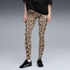 Tegen grijs draagt een model een luipaardprint legging en zwarte sportschoenen.