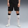 Vor grauem Hintergrund trägt ein Model ein schwarzes Trikot, Socken mit '1901' und weiße Turnschuhe.