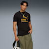 Sur fond gris, un mannequin pose avec un t-shirt graphique, un short et un sac.