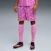 Vor grauem Hintergrund trägt ein Model pinke BVB-Fussballbekleidung mit passenden Socken und Fussballschuhen.