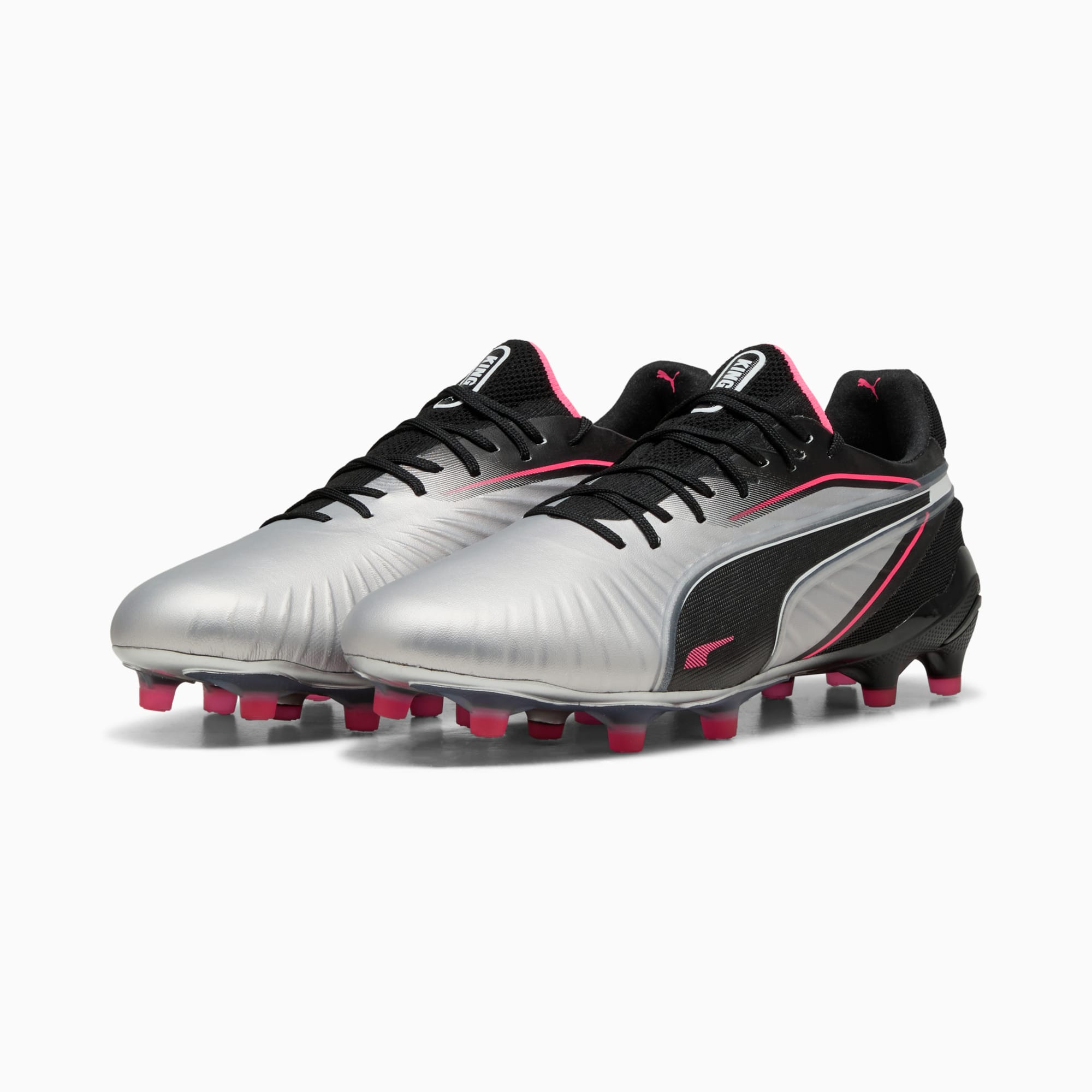 Silberne PUMA Fußballschuhe mit schwarzen Akzenten und pinkfarbenen Details für Erwachsene.