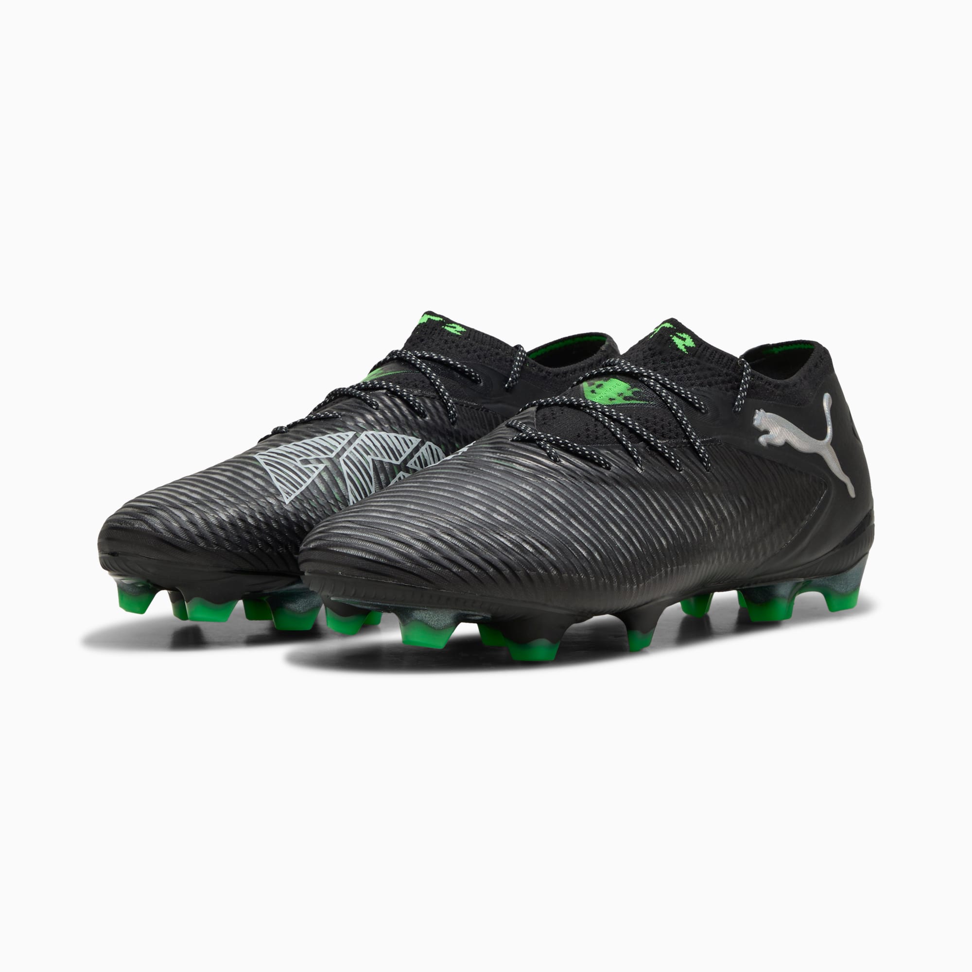 Chaussures de foot PUMA noires pour adultes, crampons verts et logo argenté.