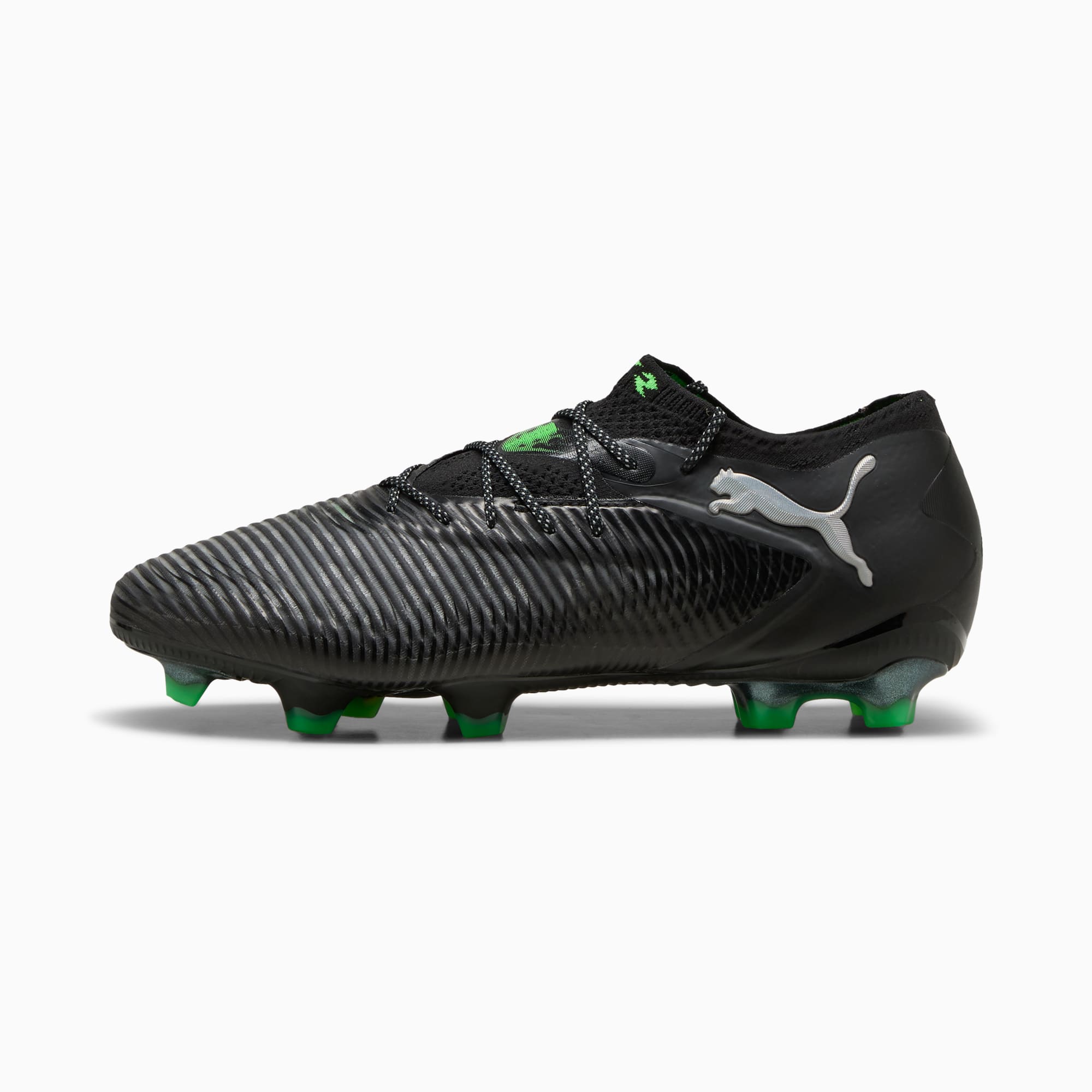 Chaussure de foot PUMA noire avec détails verts et empeigne texturée pour l'adhérence.