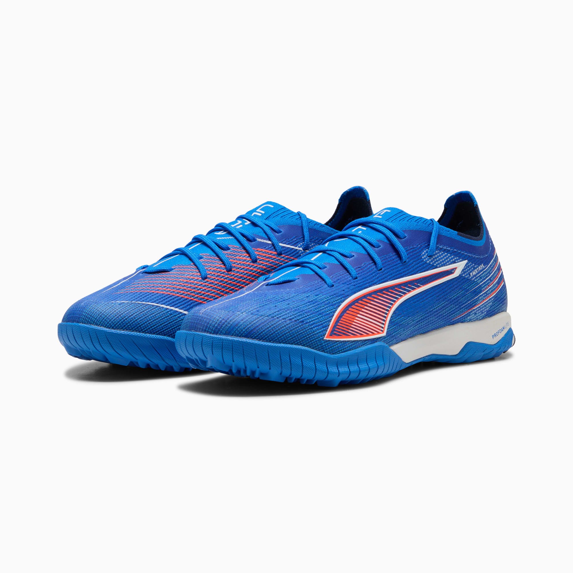 Blauwe PUMA voetbalschoenen voor volwassenen, met oranje en witte details, schuin weergegeven.