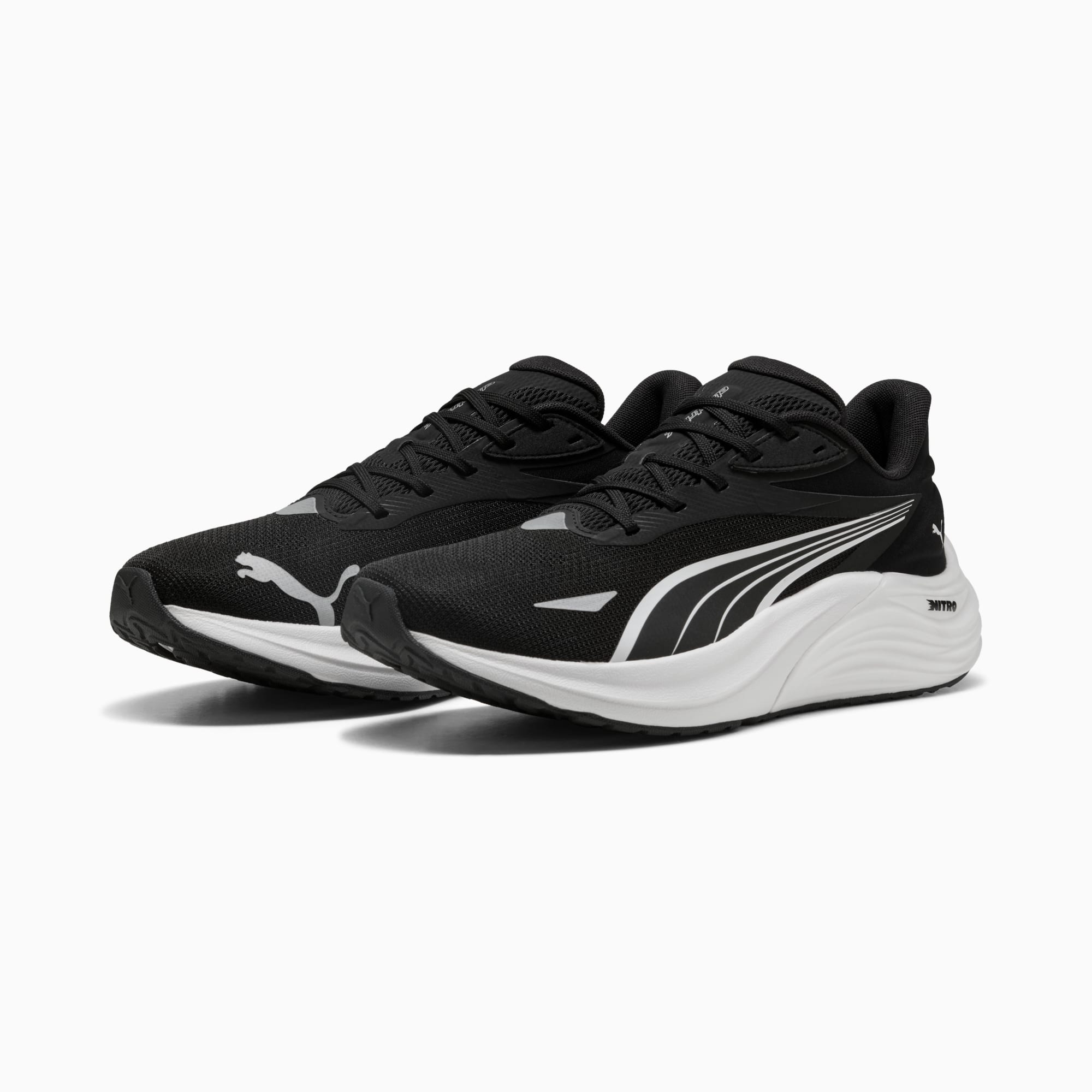 Zwarte PUMA unisex sneakers met wit logo en zool details.