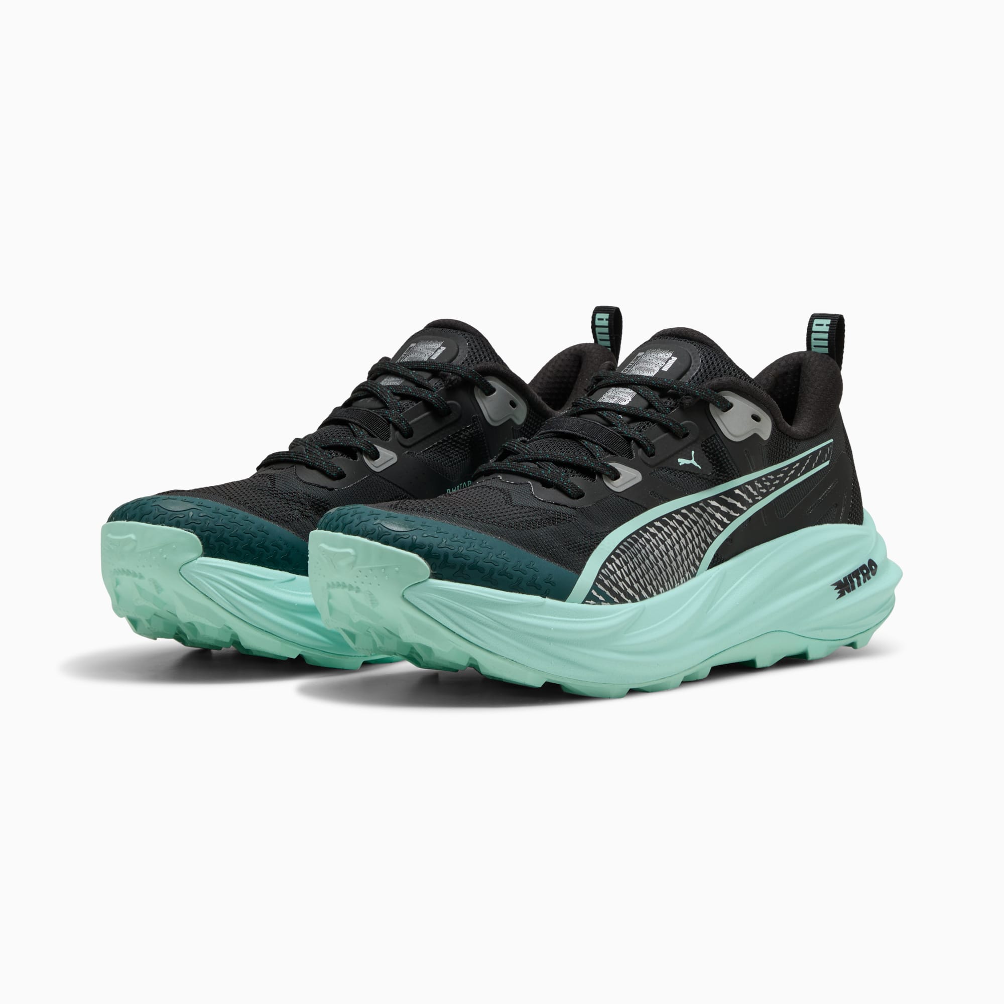 Zapatillas de running negras PUMA, de mujer, con suela color menta y raya lateral estampada.