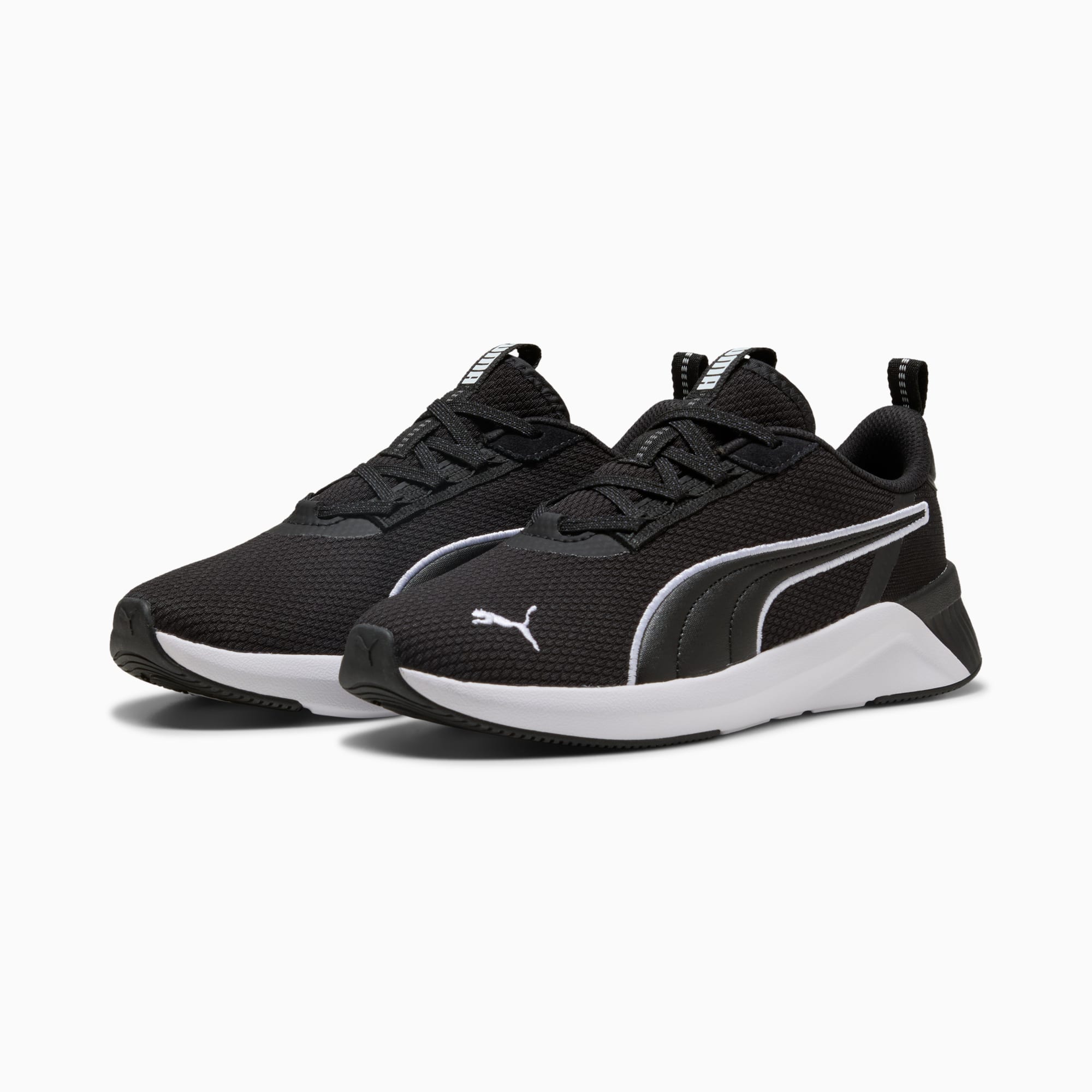 Scarpa da ginnastica PUMA nera per bambini, con logo e suola bianca.