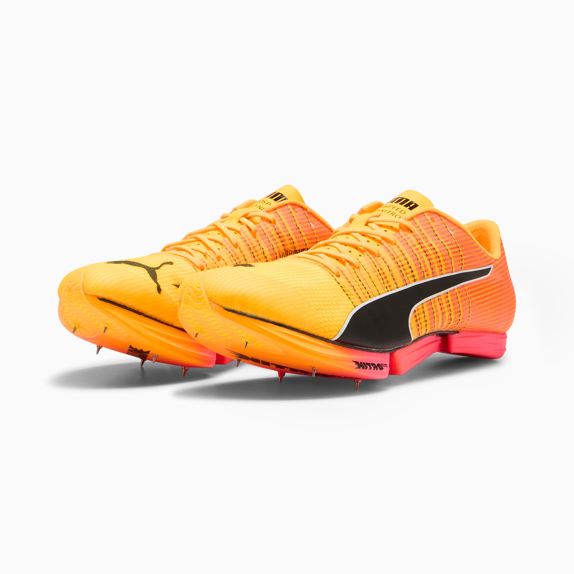 Oranje PUMA unisex-trainers met zwarte Formstrip en zool met spikes.