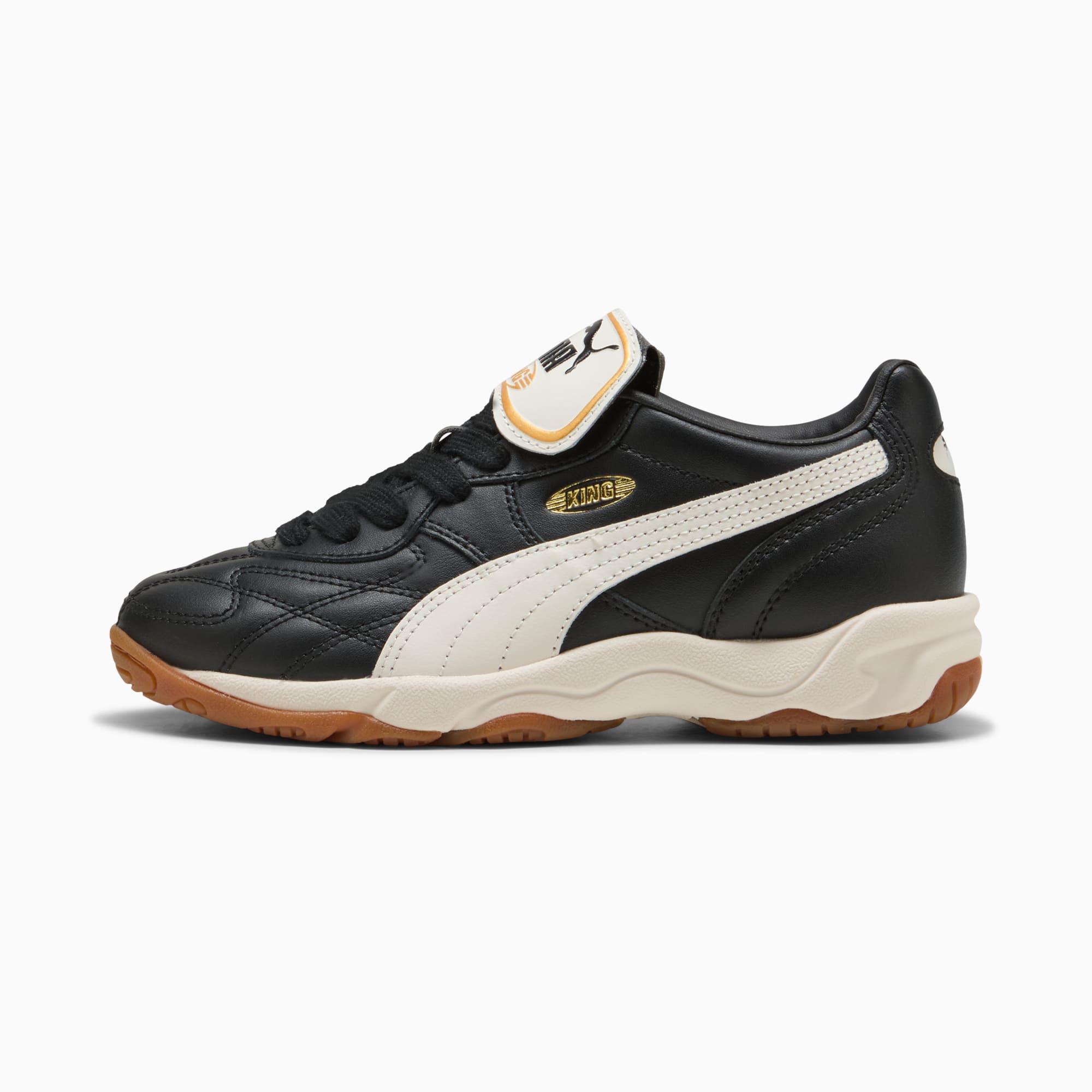 Black PUMA indoor trainer, for youth, with white formstrip and brown rubber sole.