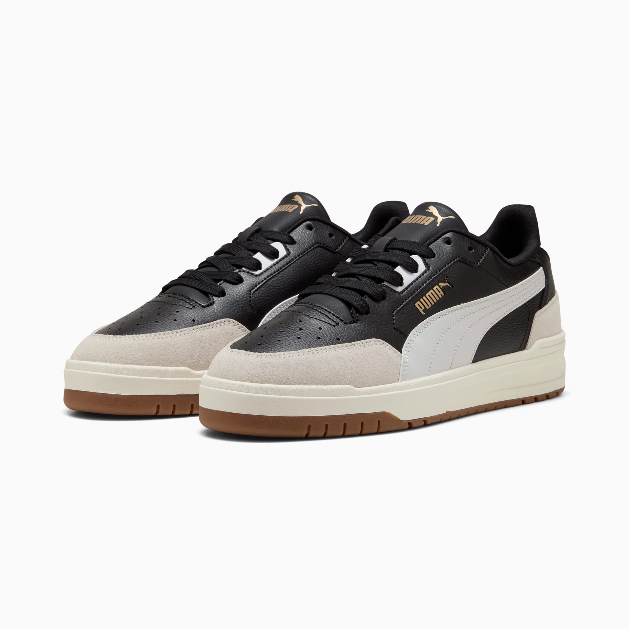 Scarpe da ginnastica PUMA nere per adulti con striscia bianca e suola beige e marrone.