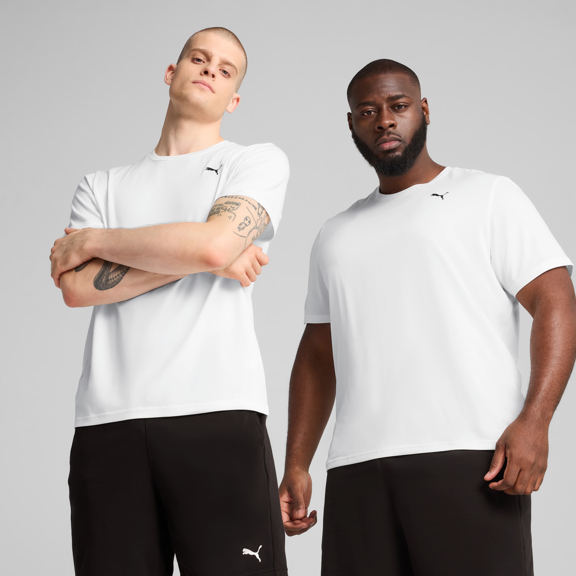 Deux modèles posent sur fond gris, portant des t-shirts blancs et des shorts noirs.
