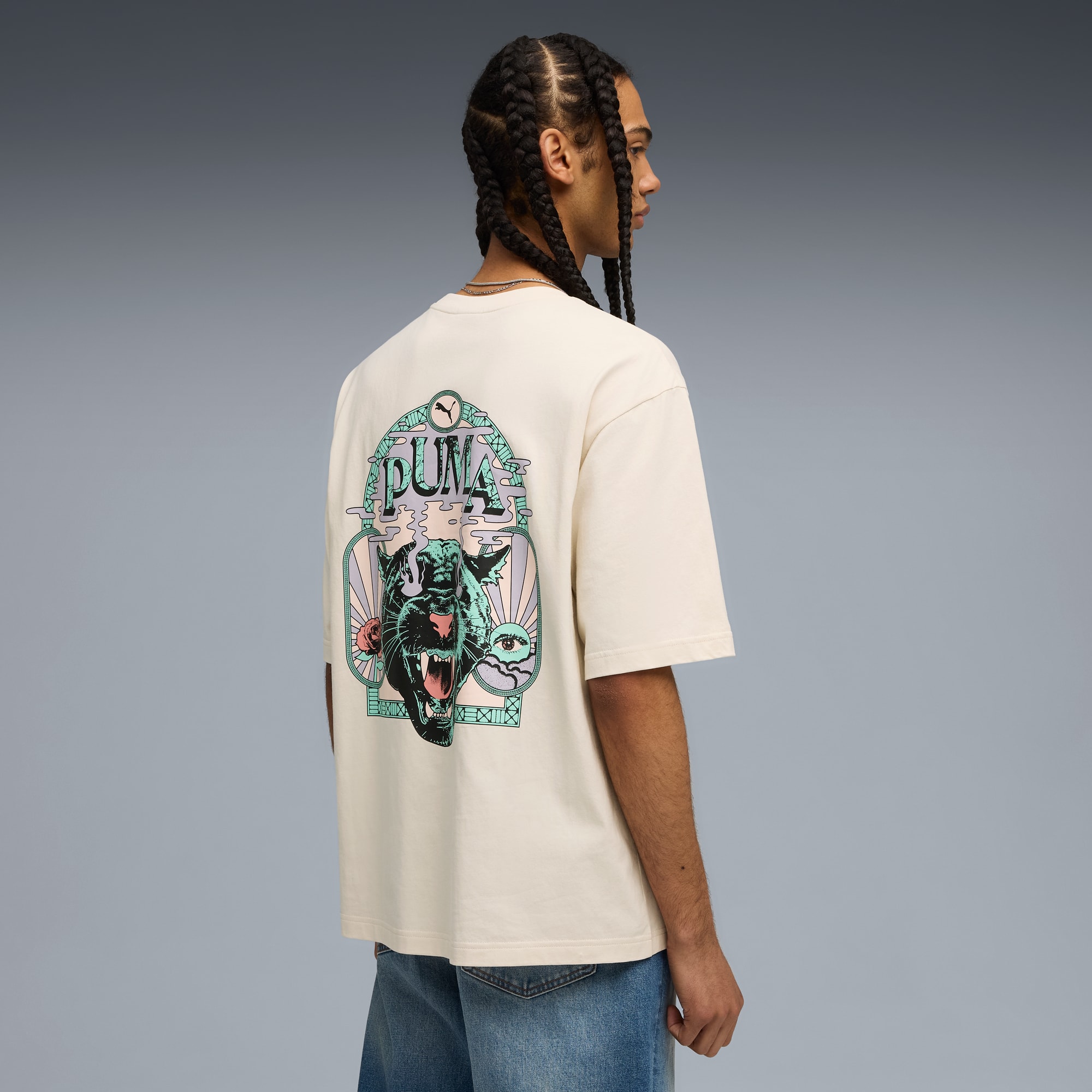 Een model staat met de rug naar de camera op een grijze achtergrond, met een Puma T-shirt.