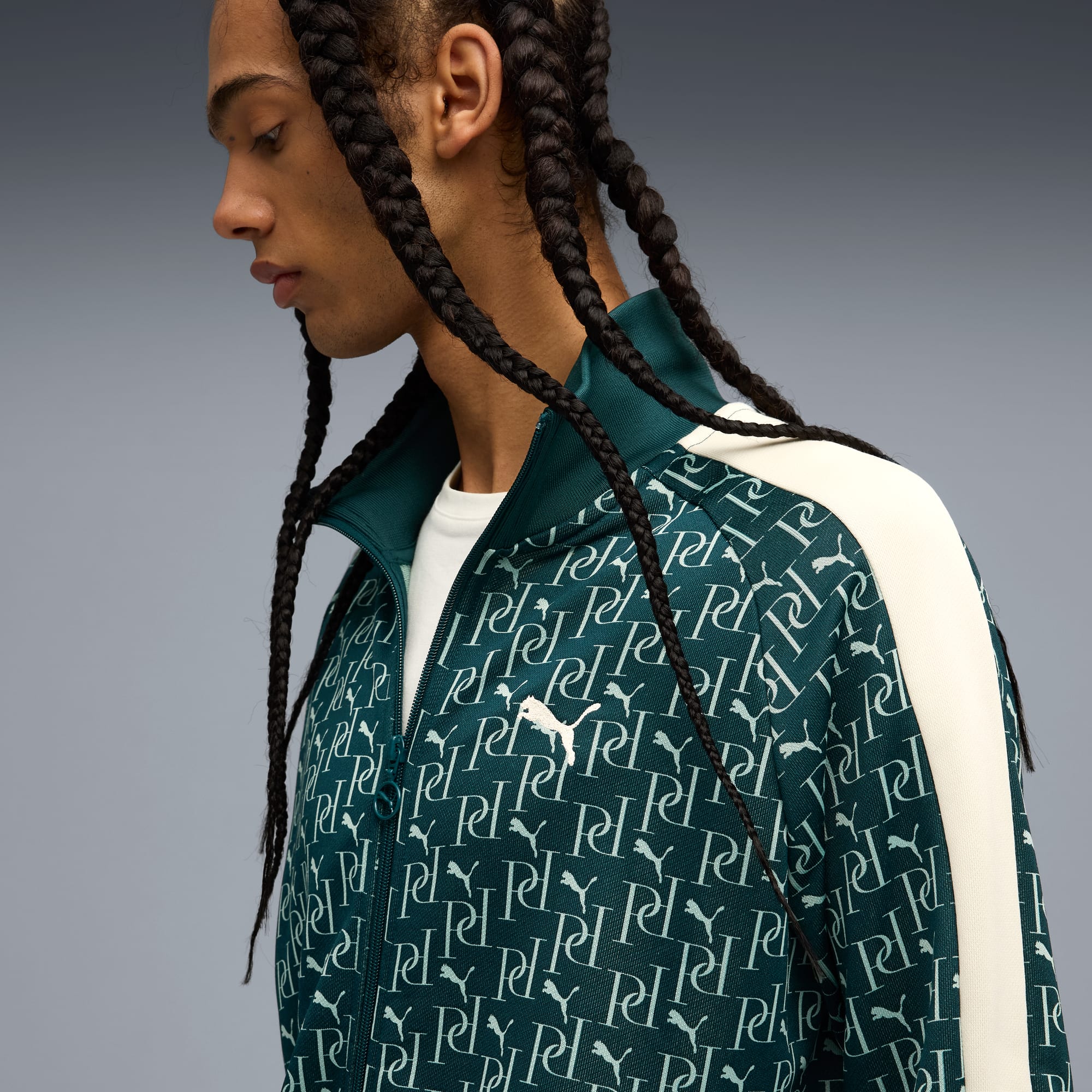 Un mannequin devant un fond gris portant une veste verte à motifs et un t-shirt blanc.