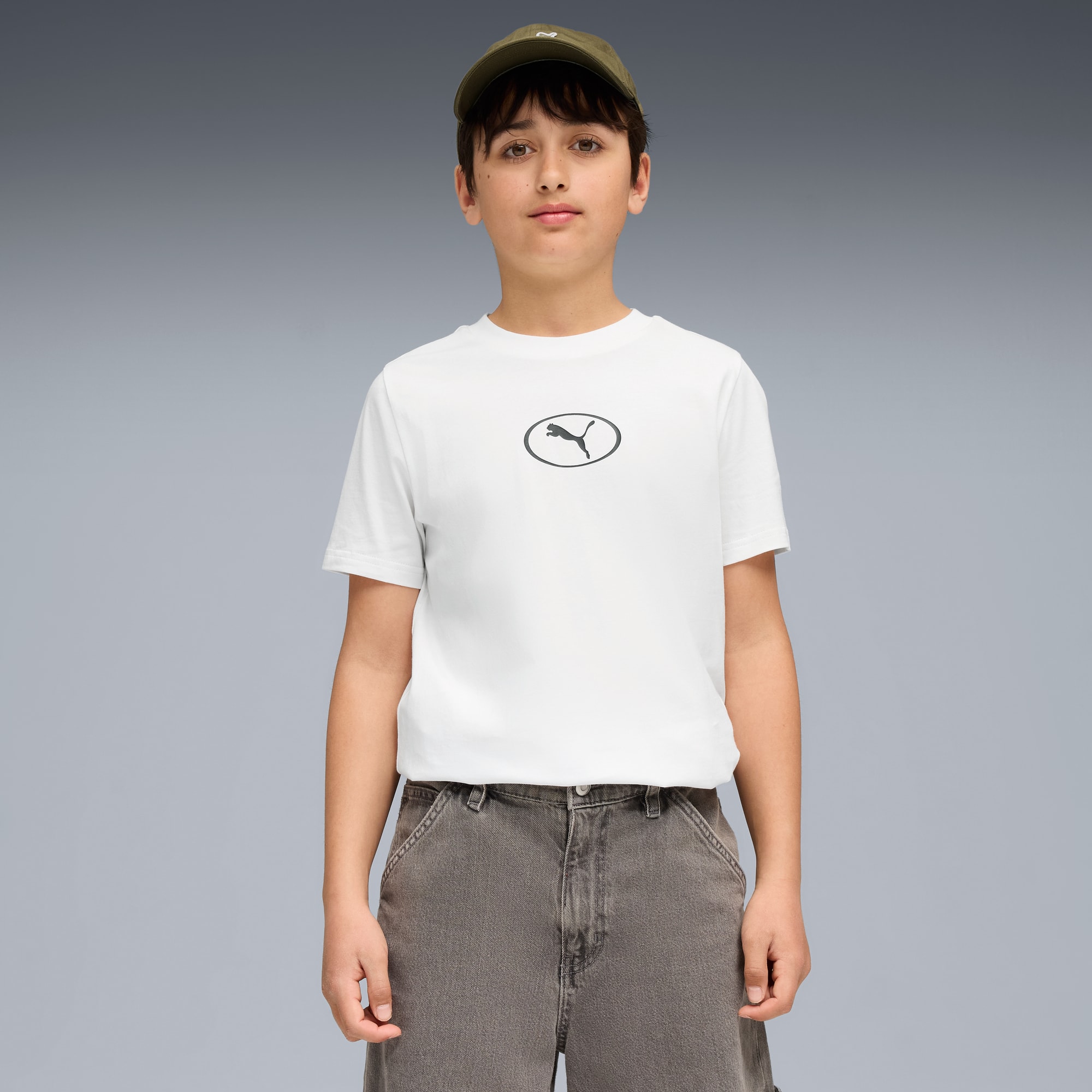 Op grijs poseert een model met T-shirt, korte broek en pet.