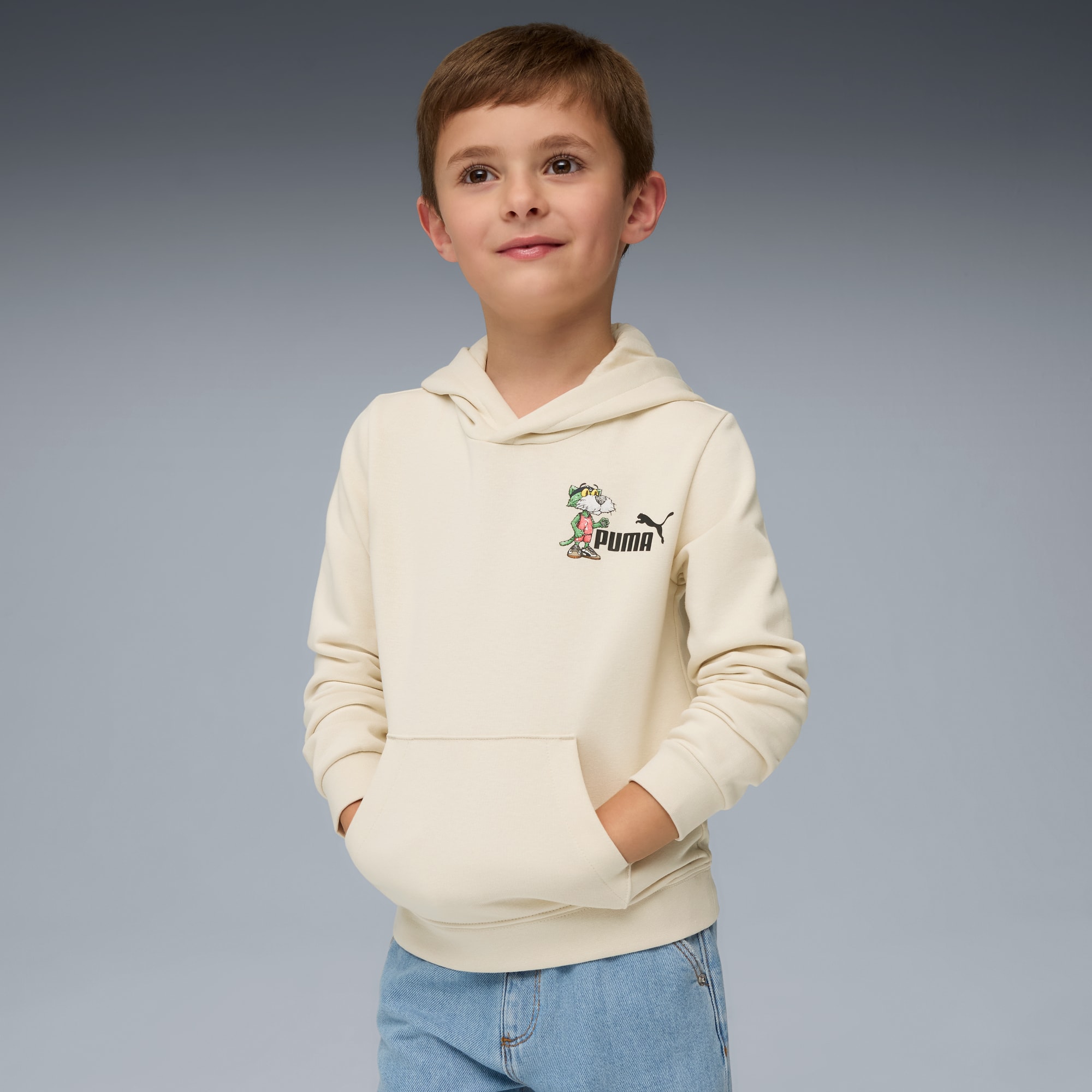 Sur fond gris, un enfant présente un sweat à capuche crème avec un personnage et un logo.