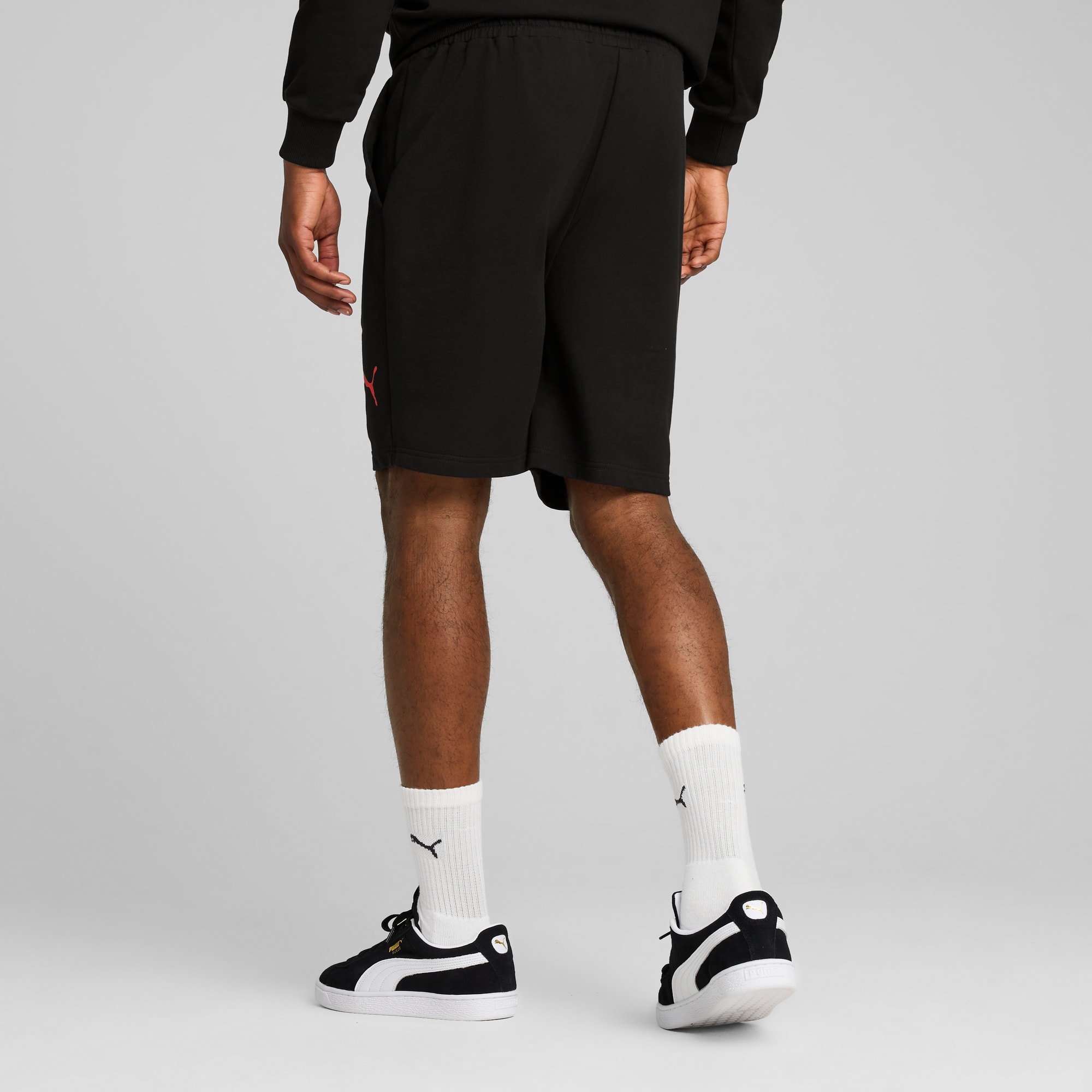 Een model staat met de rug naar de camera, draagt een korte broek, sneakers en sokken.