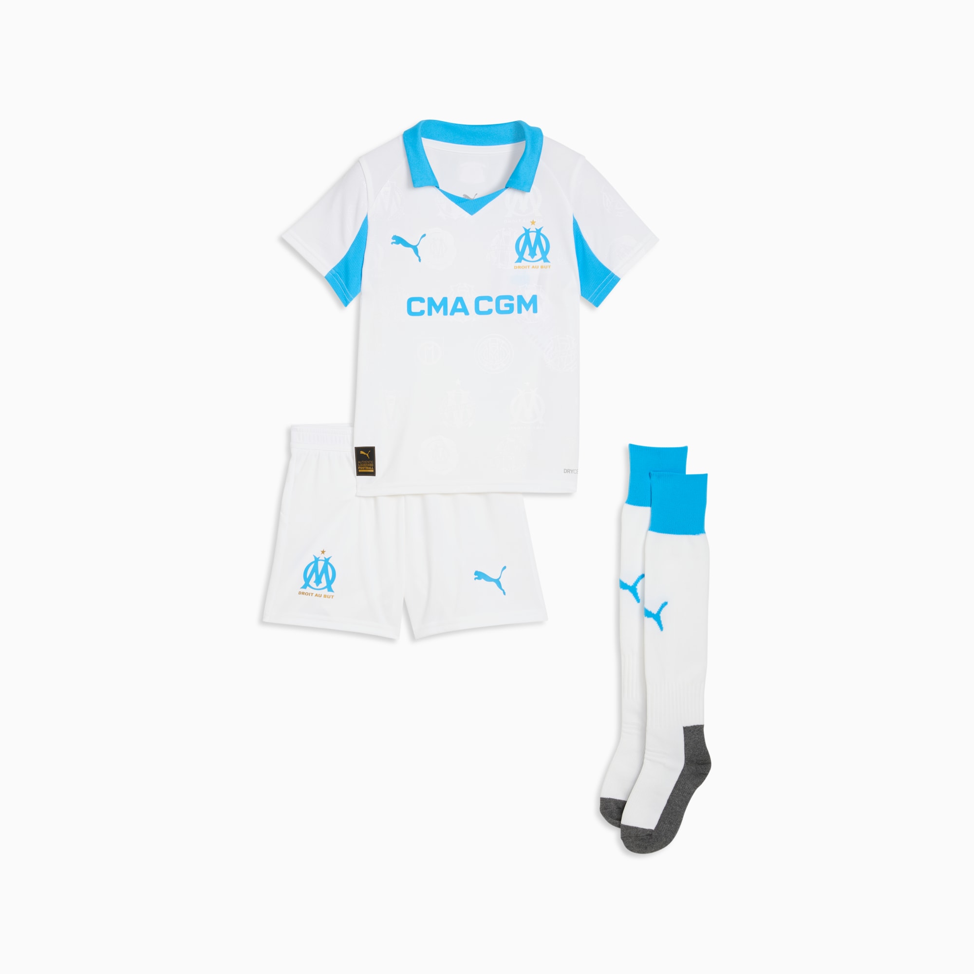 Witte PUMA set voor jongeren, met shirt, korte broek en sokken met blauwe accenten en logo's.