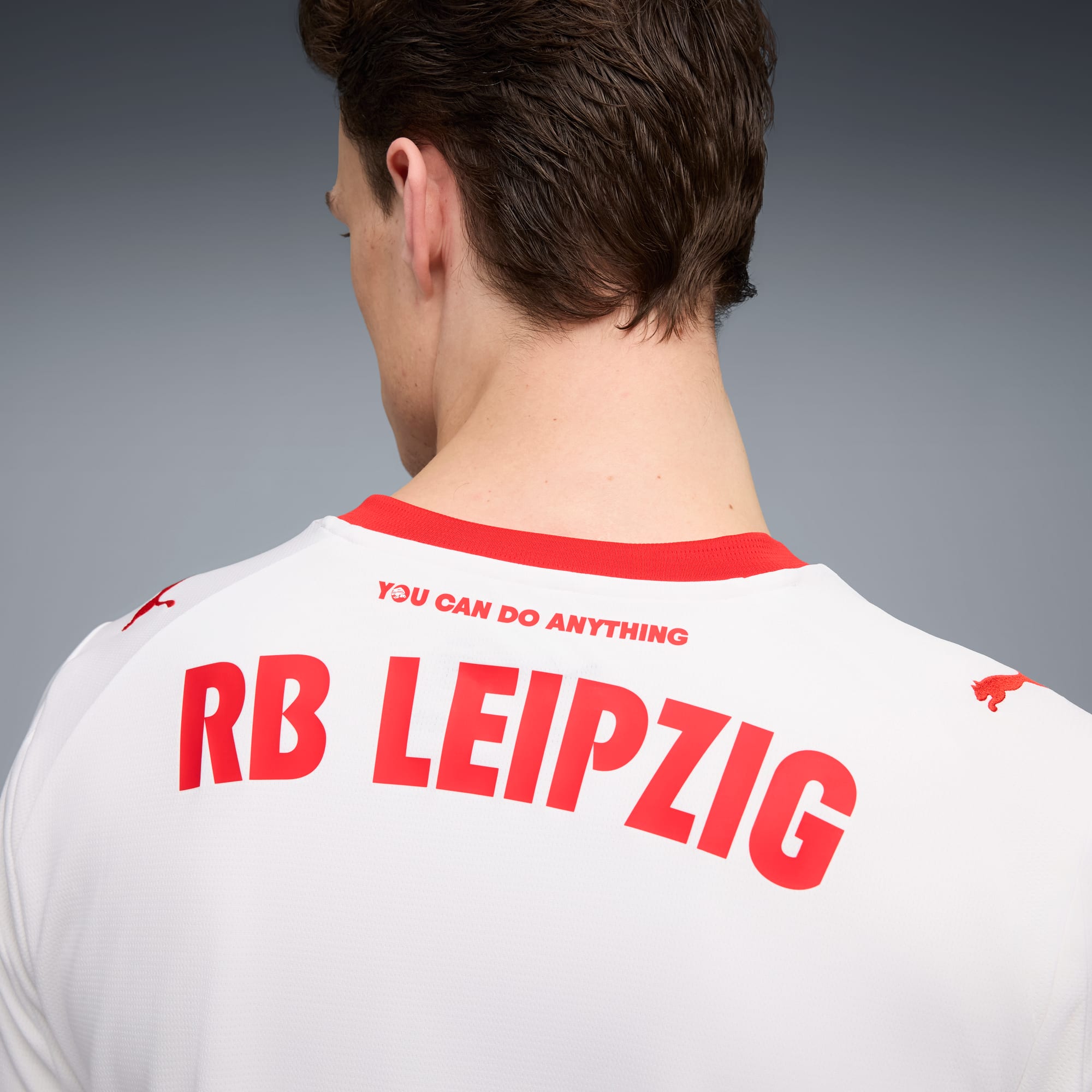 Een model, met de rug naar de camera, draagt een wit-rood RB Leipzig T-shirt.