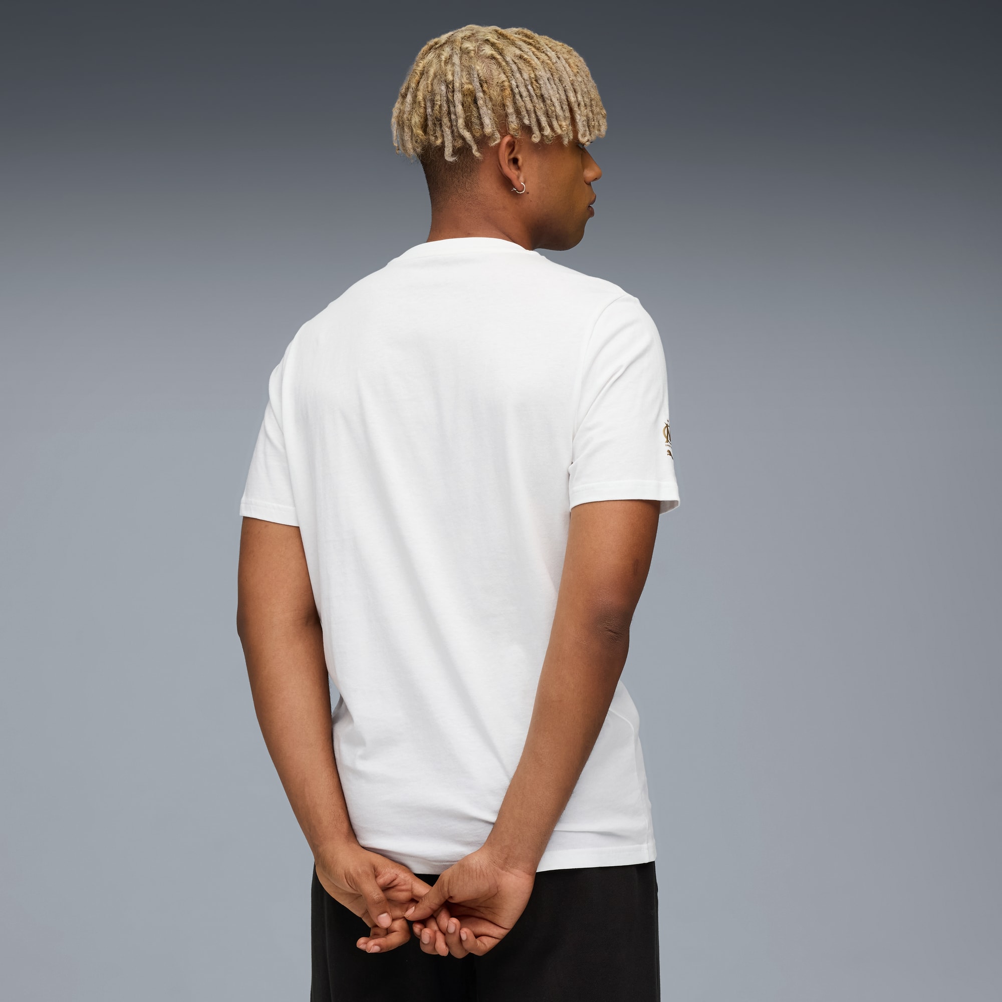 Un modèle de dos sur fond gris, portant un t-shirt blanc et un short noir.