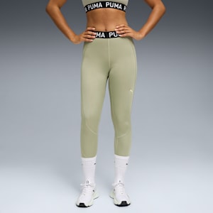 Against grey, a model poses in light green leggings, top, white socks, and trainers.