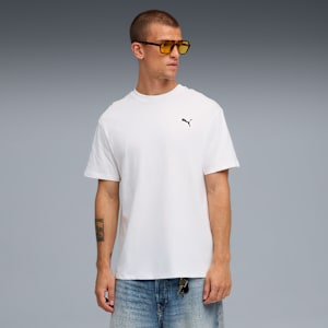 A model stands against a grey backdrop, wearing a white t-shirt, jeans and yellow sunglasses.