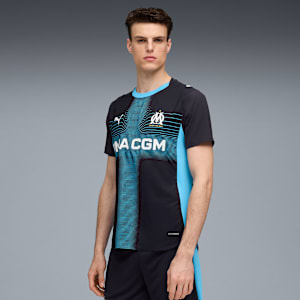 Against grey, a model wears a black t-shirt with blue accents and black shorts.