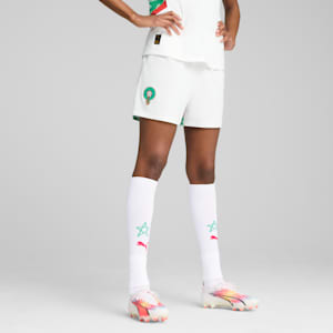 Against grey, a model is wearing white kit, socks with logo and running shoes.