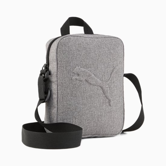 Grey PUMA reporter bag with a black strap and embossed logo detail.