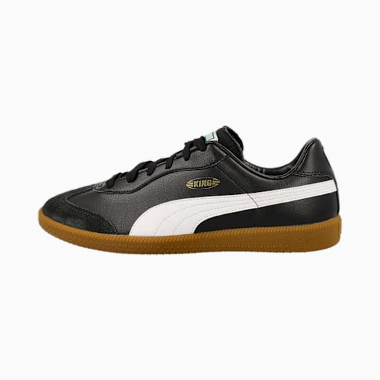 Black PUMA trainers featuring a white stripe and brown textured sole.
