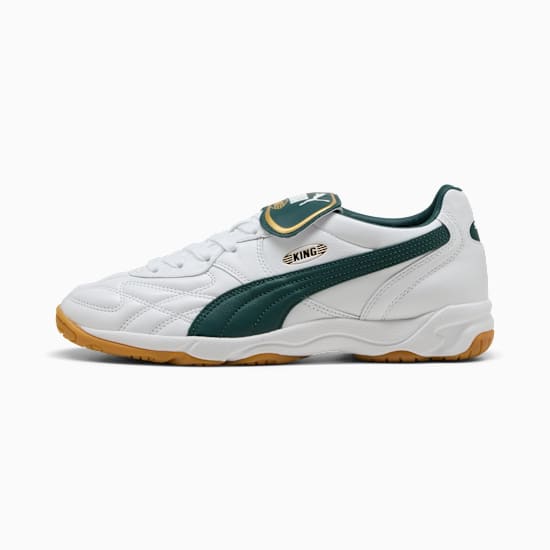 Witte PUMA-sportschoenen voor volwassenen, met groene accenten en een gomkleurige zool.