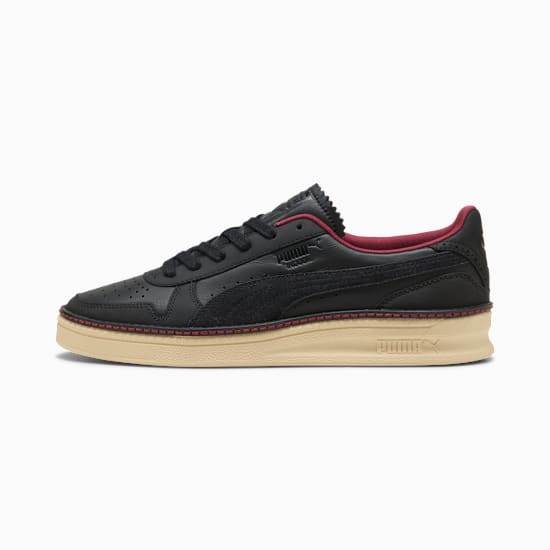 Black PUMA Unisex Trainer with red accents and a beige sole.
