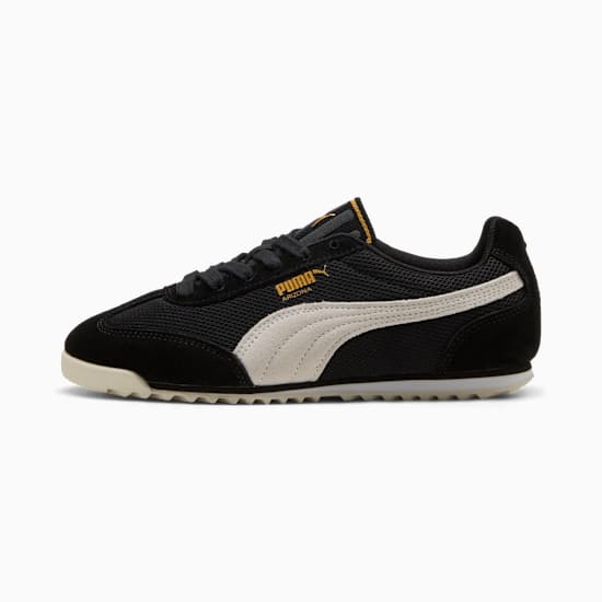 Baskets PUMA noires avec une bande latérale blanche et des lacets foncés.