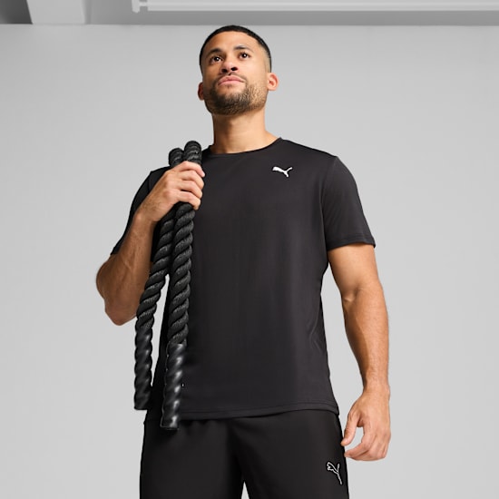 A model with a rope over his shoulder, posing against a grey backdrop in sportswear.