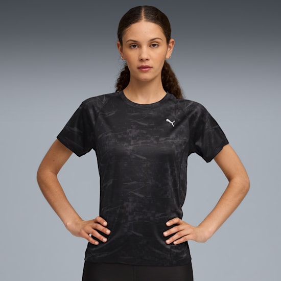 A model poses against a grey backdrop, wearing a patterned black t-shirt.
