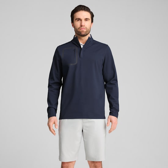 Against a grey backdrop, a model poses wearing a navy top and light grey shorts.