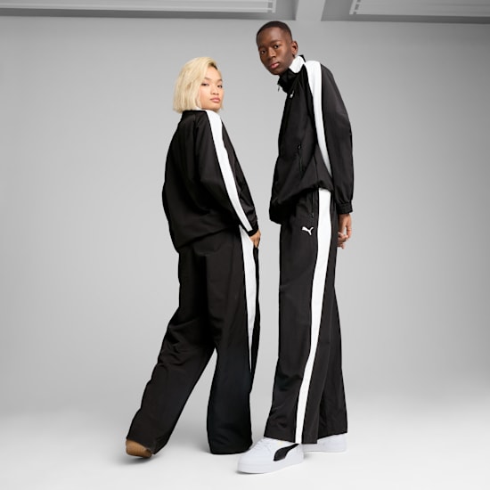 Two models pose in matching black tracksuits with white stripes against a grey backdrop.