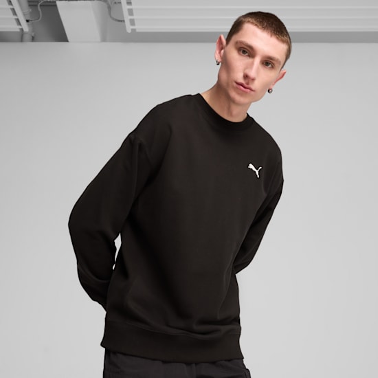 Un mannequin pose sur un fond gris, portant un sweat noir avec un logo blanc.