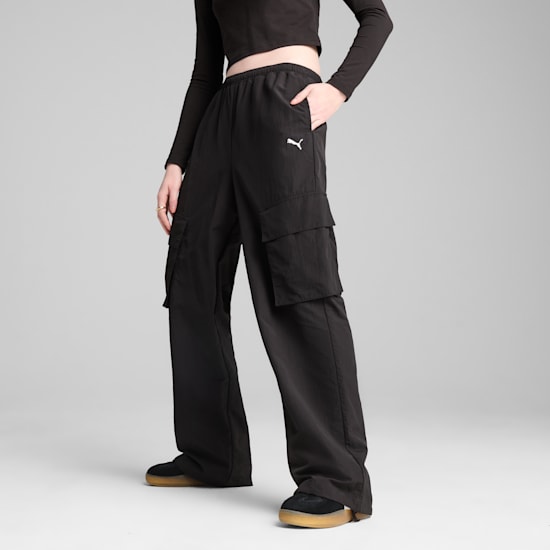 A model poses against grey, showcasing black cargo trousers with the Puma logo.