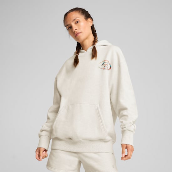 Un mannequin avec des tresses pose devant un fond gris, portant un sweat à capuche et un short.