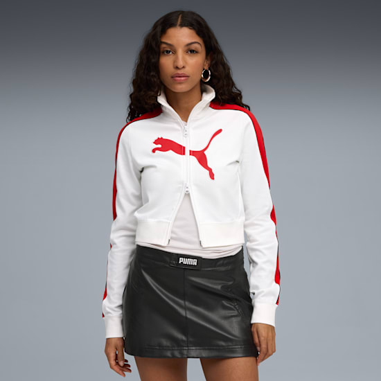 A model against grey wears a white jacket with red stripes and black skirt.