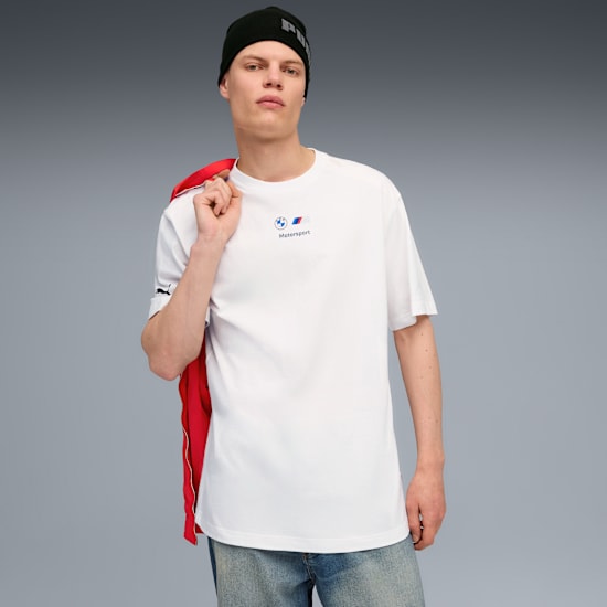 Un mannequin pose sur fond gris, vêtu d'un t-shirt blanc, d'un jean et d'un bonnet noir.