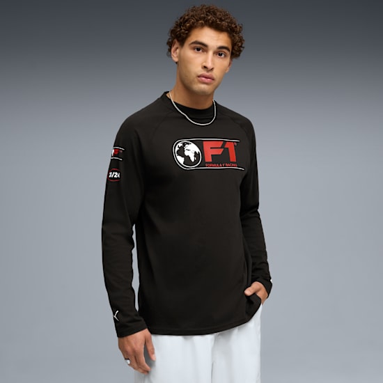 A model poses against grey wearing a black long-sleeve shirt with a red and white logo.