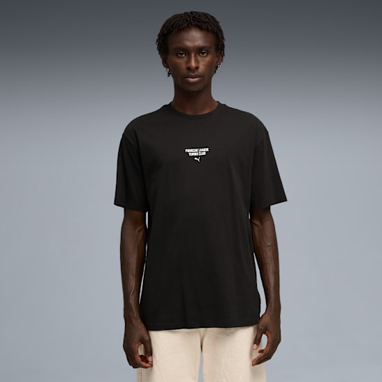 Een model staat op grijs met een zwart T-shirt met logo en een lichte korte broek.