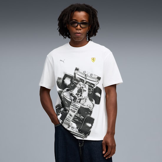 Ein Model mit Sonnenbrille posiert vor grauem Hintergrund und trägt ein bedrucktes, weißes T-Shirt.